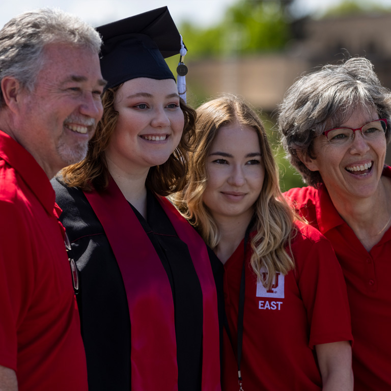 A family wearing IU East t-shirts pose for a photo with their graduate