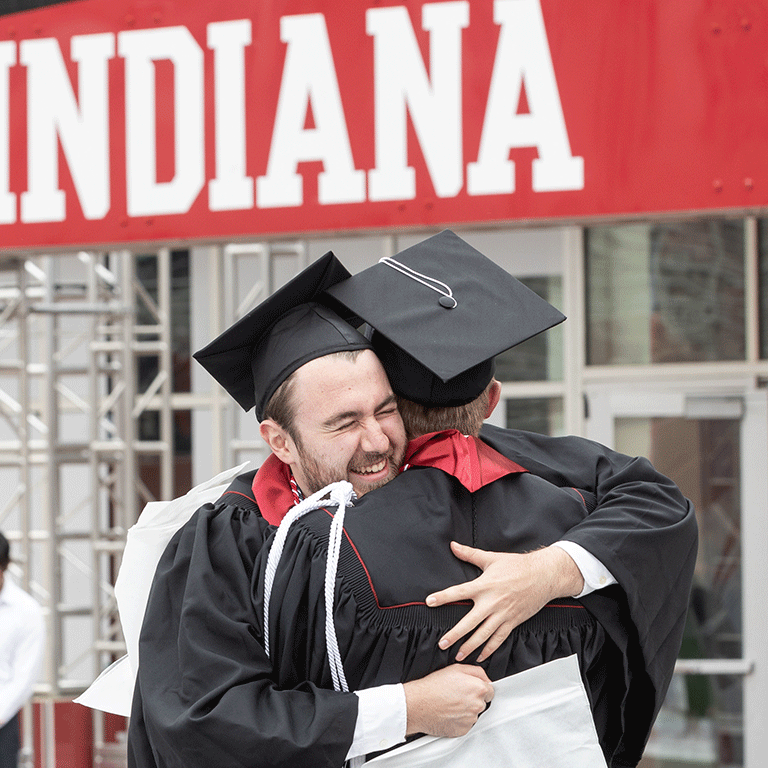 Two graduates hug.
