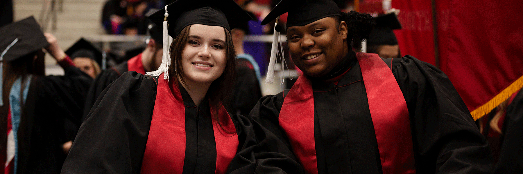 two female graduates smiling