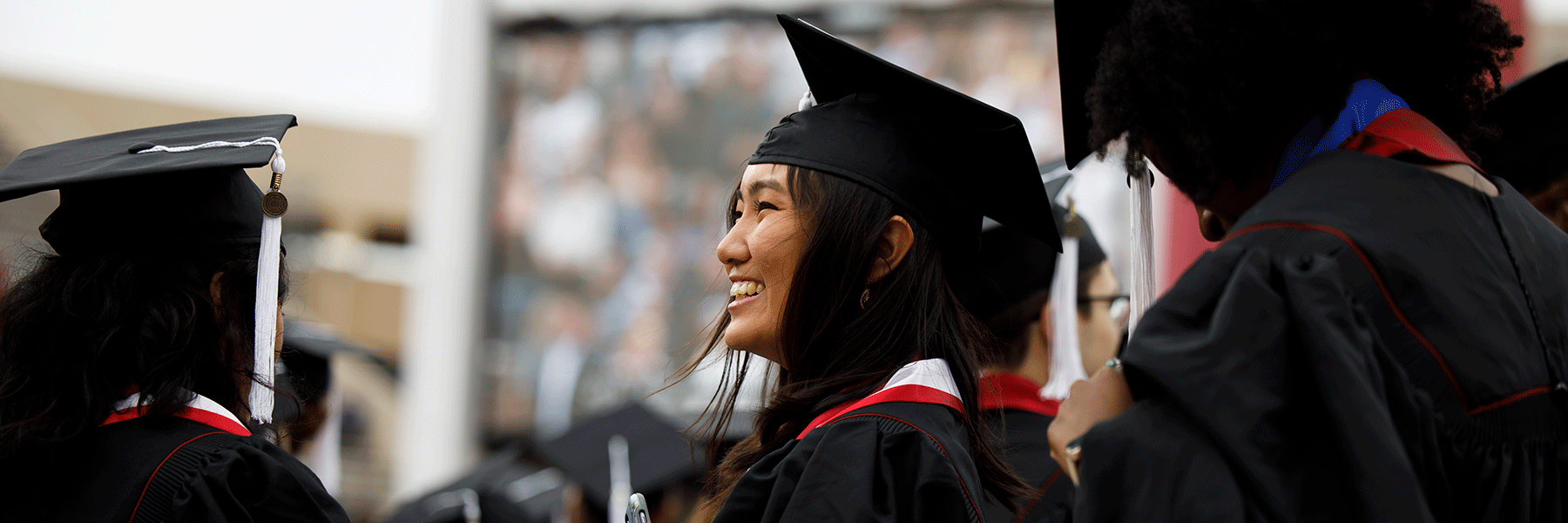 A female graduate smiles during commencement.